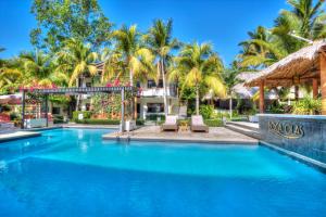 a swimming pool at a resort with palm trees at Boca Olas Resort Villas in La Libertad