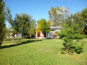 a house in the middle of a yard with trees at Cabañas Los Girasoles in Gualeguaychú