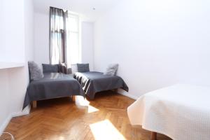a white room with two beds and a window at Krakow Townhouse in Krakow
