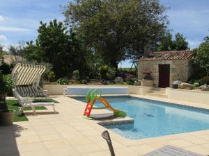 - une piscine avec un toboggan et deux chaises dans l'établissement La Piaule, à Saint-Pierre-le-Vieux