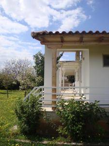 a white house with a porch and stairs on it at Three Bedroom Country House in Magoúla