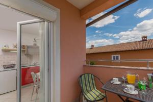 a balcony with a table and chairs and a kitchen at Guest House Gloria in Novigrad Istria