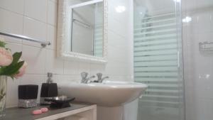 Un baño blanco con lavabo y espejo. en Alojamento Requinte, en Oporto 28 fotos más