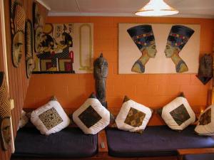 Global Village Travellers Lodge في غرايموث: مجموعة من الوسائد جالسة على أريكة في غرفة