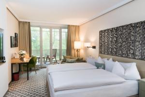 Cette chambre comprend deux lits et un bureau. dans l'établissement Parkhotel Rothof, à Munich