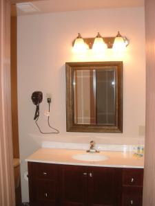 a bathroom with a sink and a mirror at The Sunset Inn in Alamosa