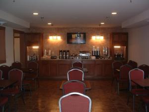 a room with chairs and a bar in a restaurant at The Sunset Inn in Alamosa