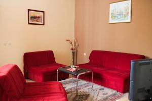 莫斯塔爾的住宿－王宮旅館，客厅配有2把红色椅子和桌子
