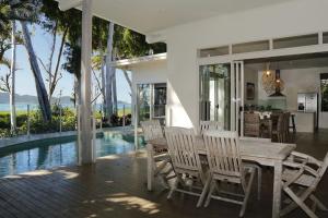 a dining room with a table and chairs next to a pool at The Boat House in South Mission Beach
