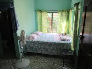 a small bedroom with a bed and a window at Villy's Cottage in Corn Islands