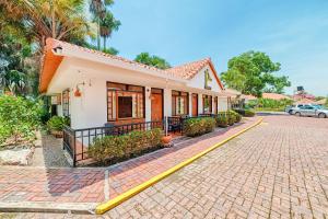 uma casa com uma mangueira amarela numa rua de tijolos em Hotel Campestre La Potra em Villavicencio
