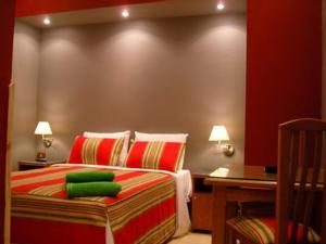 a bedroom with a bed with red walls and green pillows at Golden Hotel Cairo in Cairo