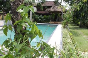 una piscina accanto a un cortile con piante di Puri Kutat Lestari a Sanur