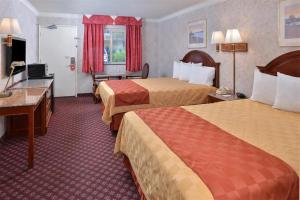 a hotel room with two beds and a desk at Americas Best Value Inn & Suites - Fontana in Fontana