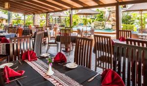 a restaurant with a black table with red napkins at Tokatoka Resort Hotel in Nadi