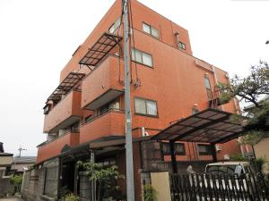 ein hohes rotes Backsteingebäude mit einer Feuertreppe in der Unterkunft Business Hotel Century in Nara