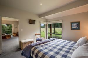 a bedroom with a blue and white checkered bed at Woodbank Park Cottages in Hanmer Springs