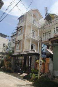 um grande edifício branco com um portão em frente em Hoang Trang Hotel em Da Lat