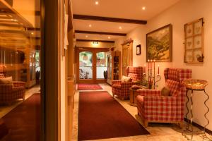 - un salon avec des chaises rouges et un tapis rouge dans l'établissement Hotel Silbertal, à Silbertal