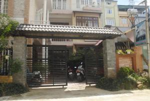 a building with a gate and a motorcycle parked in it at Hoang Trang Hotel in Da Lat