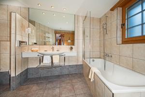 uma casa de banho com uma banheira e um lavatório e uma banheira em Hotel Dufour Chalet - Adults only em Zermatt