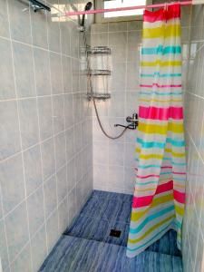 a shower with a colorful shower curtain in a bathroom at Yurt camp Meiman Ordo in Bokonbayevo