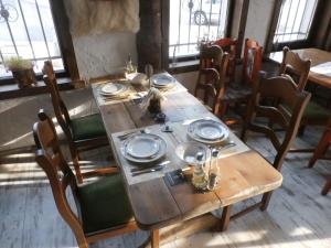 a wooden table with plates and napkins on it at Aleksandrovo Apartments in Aleksandrovo