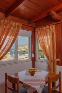 a room with a table, chairs, and a window at Nikos Hotel in Matala