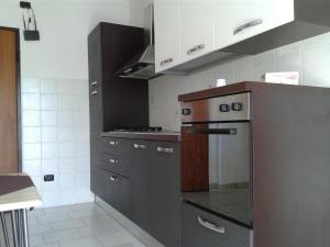 La cuisine est équipée de placards gris et d'un four avec plaques de cuisson. dans l'établissement I Gelsomini, à Melfi