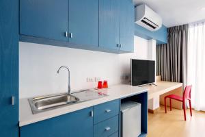 een keuken met blauwe kasten, een wastafel en een bureau bij 128 room and massage in Bangkok