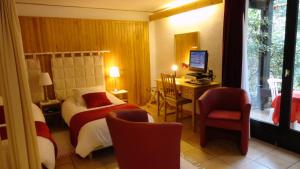 a hotel room with a bed and a desk and a television at Garden Studio Chantilly in Chantilly