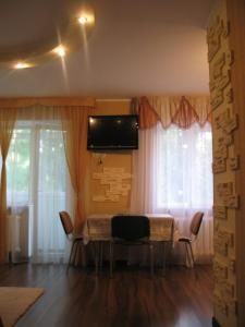 een eettafel met stoelen en een televisie aan de muur bij Apartment in Life Center Kleopatra in Krivoy Rog