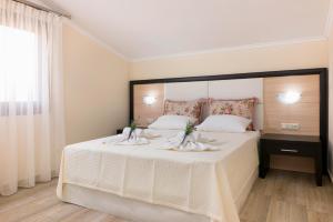 アストリスにあるStudios Gagosのベッドルーム(花の飾られた白い大型ベッド付)