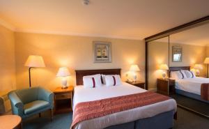 a hotel room with a bed and a chair at Coventry Hotel By Belvilla near City Centre in Coventry