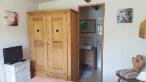 a room with a large wooden cabinet with hearts on it at Gîte Ti-Case in Bussac-Forêt