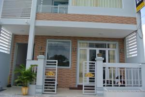 a house with white railing and a balcony at Nhà Nghỉ HOA LÝ in Chau Doc