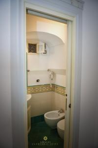 a small bathroom with a sink and a toilet at Amalfi Cathedral Suite in Amalfi