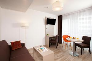 a living room with a couch and a table at Residhome Paris Rosa Parks in Paris