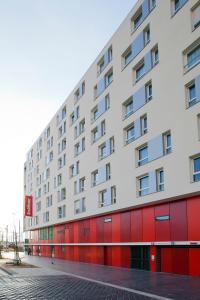 a white and red building on a street at Residhome Paris Rosa Parks in Paris