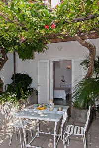 een patio met een tafel en stoelen en een slaapkamer bij Villa Rosa in Positano