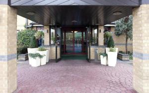コベントリーにあるCitrus Hotel Coventry South by Compass Hospitalityの鉢植えの戸付き建物の入口