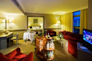 クシャダスにあるFantasia Deluxe Hotelのベッドとテレビがあるホテルの部屋