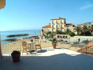 un balcón con mesa y sillas y un edificio en New Hotel Sonia, en Santa Maria di Castellabate