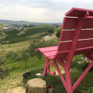een roze stoel bovenop een heuvel bij Monteverde Apartments in Acqui Terme