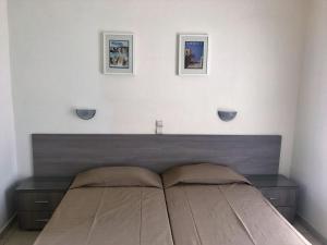 a bedroom with a bed and two lamps at Hotel Karyatides in Agia Marina Aegina