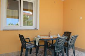 stół i krzesła w pokoju z oknem w obiekcie Apartment MARA w mieście Šilo