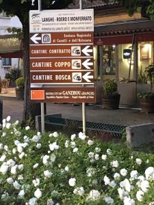 een straatbord in een bloemenveld bij Monteverde Apartments in Acqui Terme
