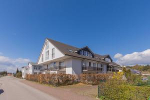 a large white house on the side of a street at Ferienwohnung Ihr Zuhause am Meer in Thiessow