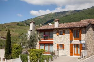 a stone house with a mountain in the background at Agriturismo Il Follo in Valdobbiadene
