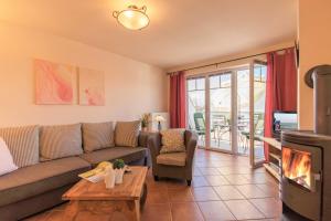 a living room with a couch and a fireplace at Ferienwohnung Ihr Zuhause am Meer in Thiessow